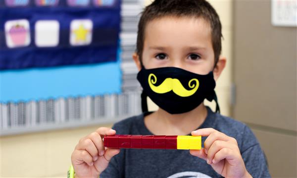 boy smiles while wearing mask